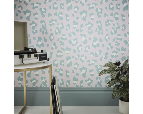 Raum mit Tapete im Animal-Print-Design, Tisch mit Plattenspieler und Zimmerpflanze