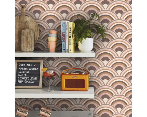 Regale mit Schneidebrettern, Geschirr, Pflanzen, Büchern, Cocktailglas, Radio, Cocktailkarte und Tapete mit Bogenmuster