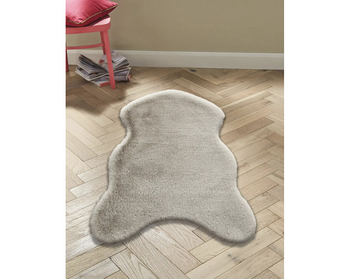 Tapis décoratif imitation peau de mouton sur parquet.