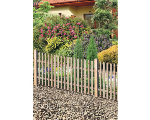 Gartenzaun aus Holz vor einem blühenden Garten