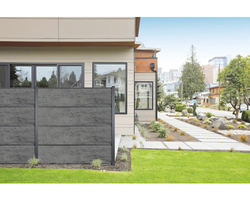 Maison moderne avec clôture en béton gris vers le jardin