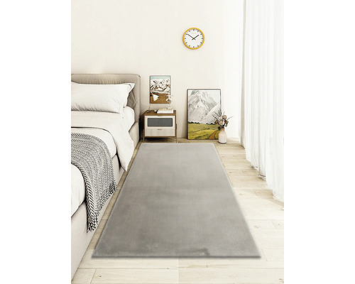 Tapis gris dans chambre avec lit et table de chevet