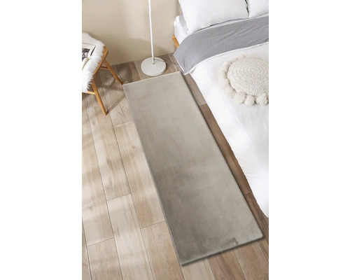 Chambre avec tapis, lit, lampe et chaise