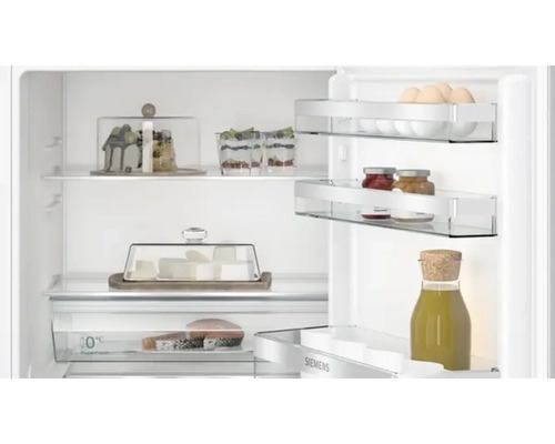 Innenansicht eines Kühlschranks mit Lebensmitteln auf Glasböden und in Behältern.