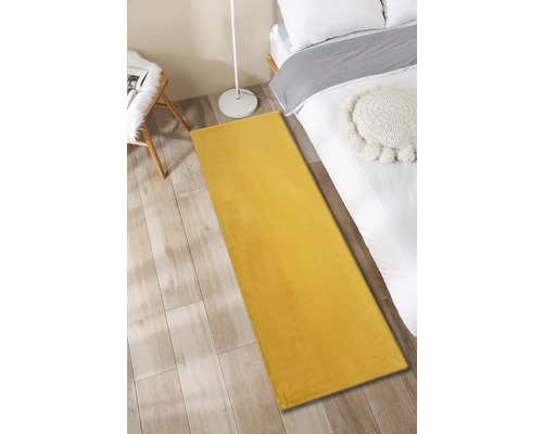 Tapis jaune dans une chambre à coucher à côté d''un lit, d''une table d''appoint et d''un lampadaire.