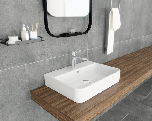 Badezimmer mit Waschbecken, Spiegel und Ablagefläche