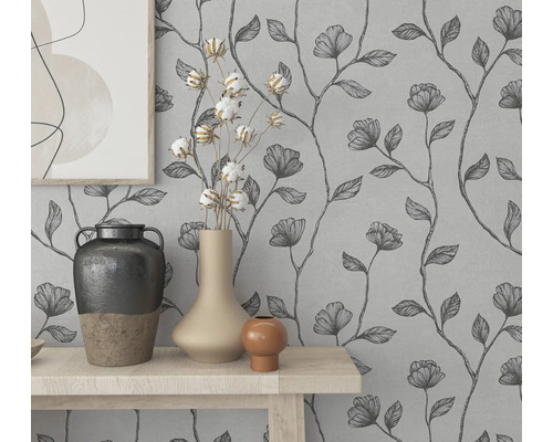 Décoration murale avec papier peint à fleurs et vases décoratifs sur une table.