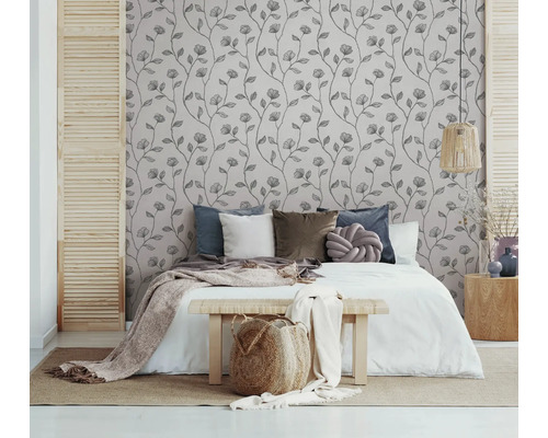 Chambre avec papier peint à motifs floraux, lit et éléments en bois pour une atmosphère naturelle et paisible