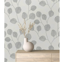 Papier peint à motif de feuilles dans une pièce avec un vase sur une commode.