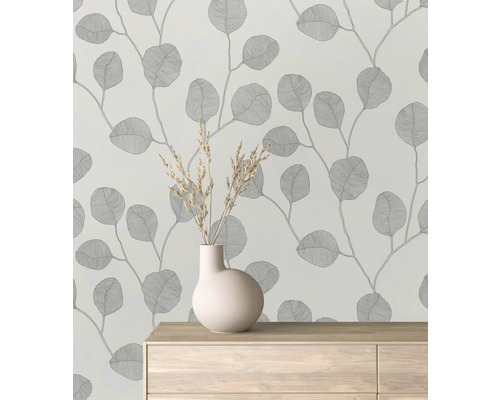 Papier peint à motif de feuilles dans une pièce avec un vase sur une commode.