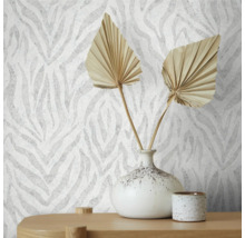 Nahaufnahme einer Wand mit Tapete im Zebra-Stil, dekoriert mit einer Vase und getrockneten Blättern