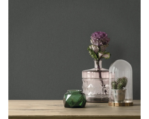 Accessoires décoratifs sur une table devant un papier peint foncé