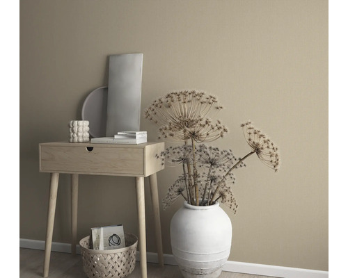Arrangement décoratif avec table d''appoint, vase avec fleurs séchées et éléments décoratifs devant un mur uni.