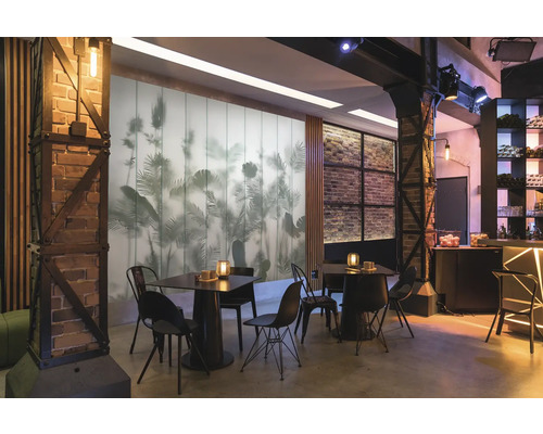 Innenraum mit Tischen, Stühlen und dekorativer Wandgestaltung mit Pflanzenmotiven