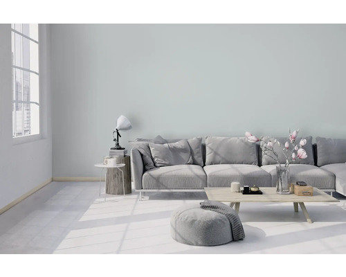 Salon lumineux avec canapé, tabouret, table et décoration