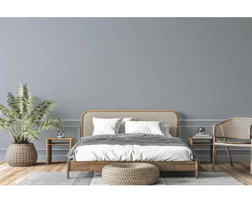 Chambre lumineuse avec lit en bois, meubles en rotin, plante d''intérieur et tapis