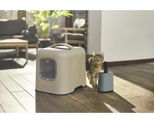 Katze neben Katzentoilette und Müllbehälter