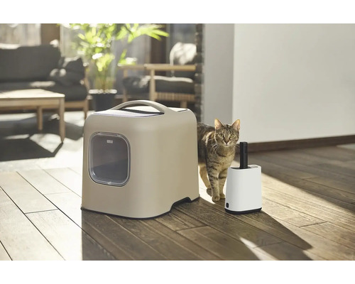 Katze neben einer geschlossenen Katzentoilette und einem Katzenstreuschaufel-Set.