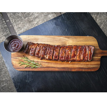 Spareribs mit Sauce auf Holzbrett