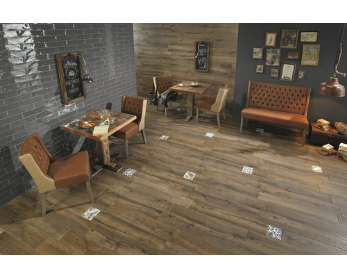 Salle à manger avec carrelage imitation bois et tables avec chaises.