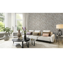 Wohnzimmer mit Couch, Tisch und Ziegelwand
