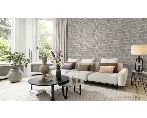 Salon avec canapé, table et mur de briques