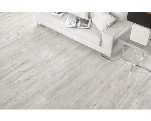 Salon lumineux avec carrelage imitation bois, canapé et table d''appoint