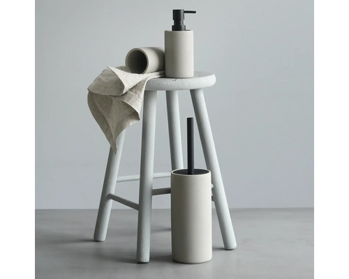 Ensemble d''accessoires de salle de bains avec distributeur de savon, gobelet, brosse de toilette et serviette sur un tabouret