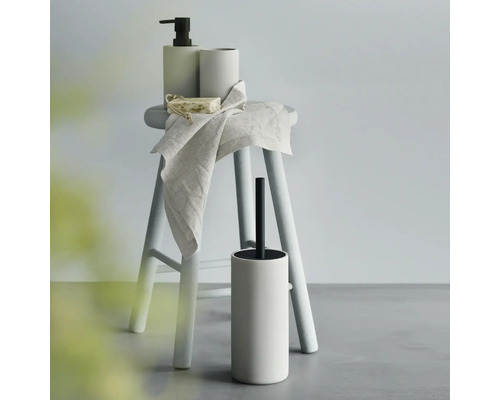 Ensemble de salle de bain avec distributeur de savon, gobelet à brosse à dents, savon, serviette et brosse de toilette sur un tabouret