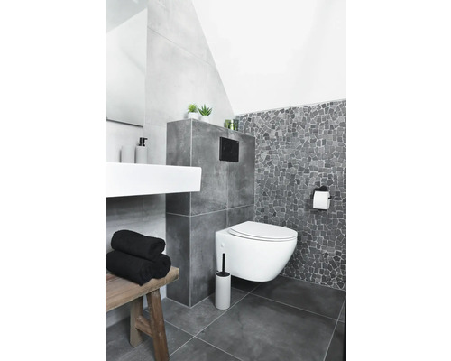Salle de bains moderne avec WC suspendu, lavabo et tabouret en bois.