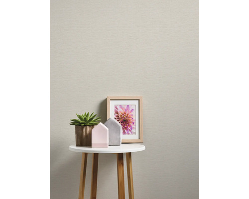 Vue d''une pièce avec du papier peint beige, une table, une plante et de la décoration