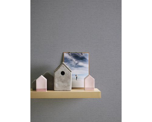 Éléments décoratifs sur une étagère : nichoirs en béton et en bois et une photo avec une représentation du ciel.