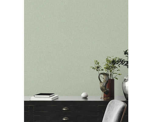 Papier peint clair et structuré dans un salon avec des meubles sombres et des éléments décoratifs.