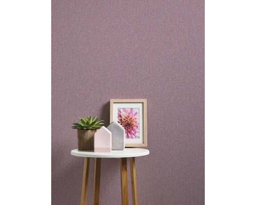 Gros plan d''un mur avec du papier peint textile, décoré d''une table, d''une plante et d''un cadre photo