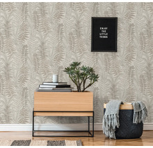 Espace de vie avec papier peint à motifs, plante et décoration pour une ambiance chaleureuse.