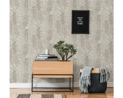 Espace de vie avec papier peint à motifs, plante et décoration pour une ambiance chaleureuse.