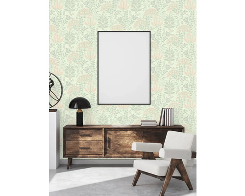 Salon avec papier peint à motifs floraux, commode, fauteuil et cadre photo