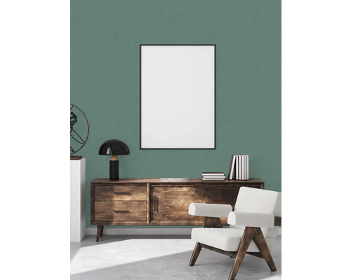 Wohnzimmer mit Holzkommode, Sessel und Bilderrahmen