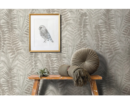 Scène avec papier peint à motif de fougère, image d''oiseau encadrée, coussin rond et décoration sur un tabouret en bois