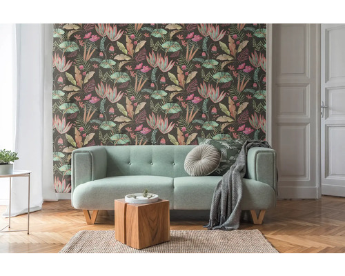 Salon avec papier peint à motifs, canapé et plancher en bois
