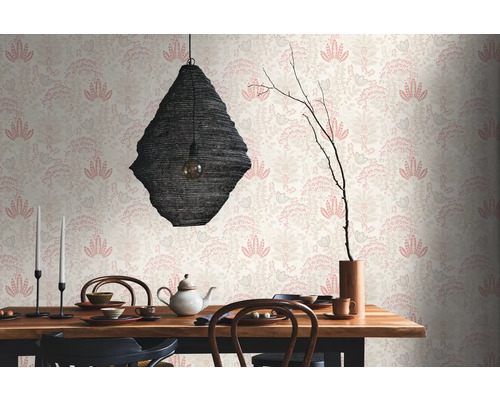 Table à manger décorée devant un papier peint à motifs floraux et une suspension