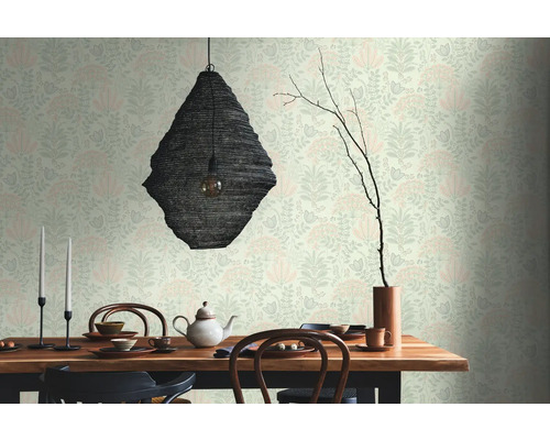 Salle à manger avec table, vaisselle, théière, chandeliers, lampe et papier peint à motifs floraux