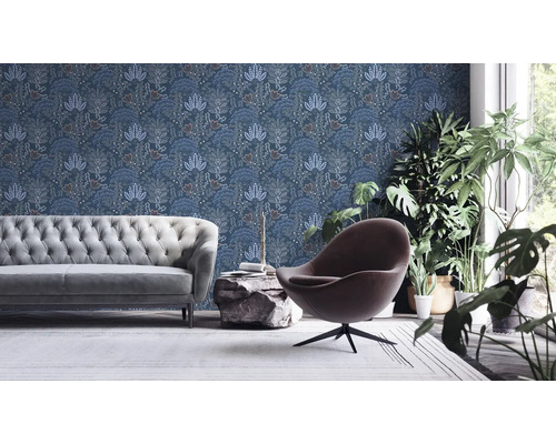 Salon avec canapé, fauteuil, plantes et papier peint à motifs