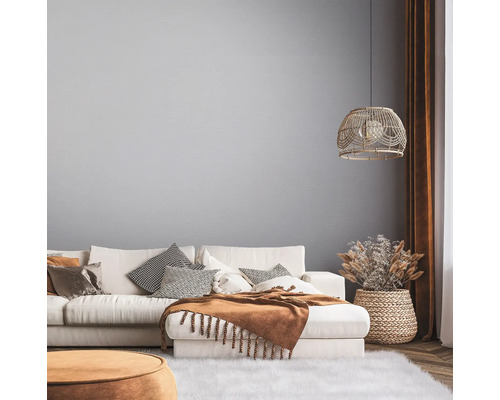 Salon lumineux avec canapé, coussins, plaid et décorations dans un design naturel