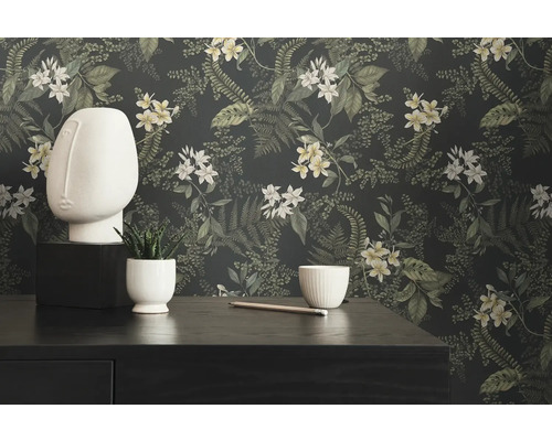 Dekoratives Stillleben mit Blumentapete, Skulptur und Pflanze auf Kommode