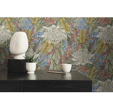 Dekoratives Interieur mit Blumentapete, Gesichtsskulptur und Pflanze im Topf auf einem dunklen Tisch.