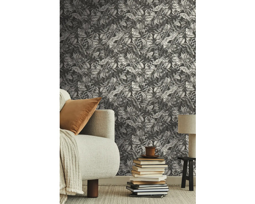 Scène avec un papier peint à motif végétal, un canapé et une pile de livres