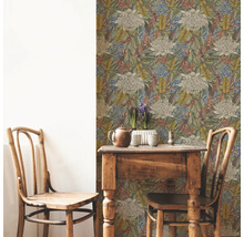 Raumansicht mit floral gemusterter Tapete, Holztisch und zwei Holzstühlen.