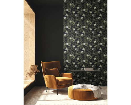 Wohnzimmer mit Sessel, Hocker und floraler Tapete für ein gemütliches Ambiente