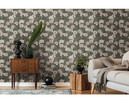 Salon avec papier peint floral, canapé et meubles en bois